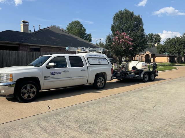 RC Pressure Washing TX branded pickup truck and pressure washing trailer rig parked in a residential driveway in Spring, TX