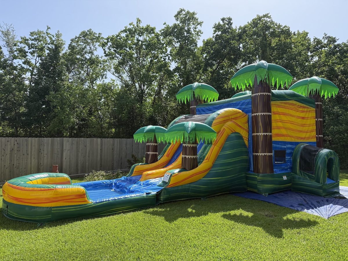 Conroe Splash Co. tropical combo bounce house with dual water slide and splash pool set up in a Conroe, TX backyard